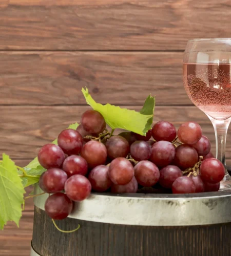 racimo-de-uvas-sobre-barril-de-madera